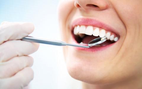 A close-up shot of a dental mirror looking at a patients teeth